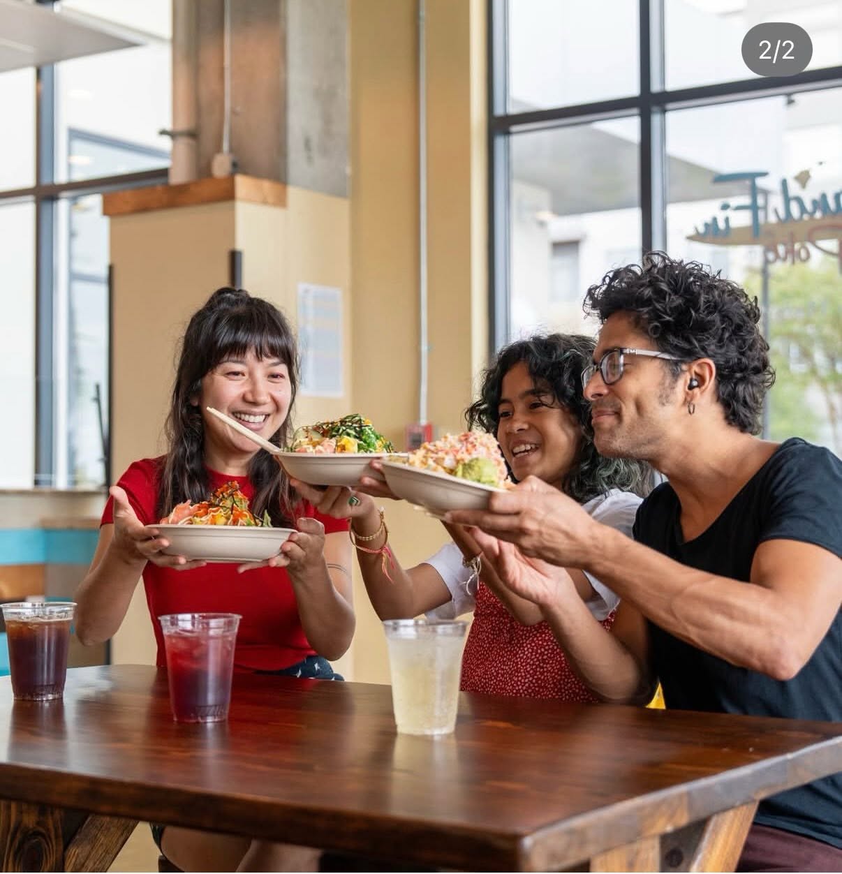 Friends sharing colorful Island Fin Poké bowls at the Beachwalk location in St. Johns, Florida